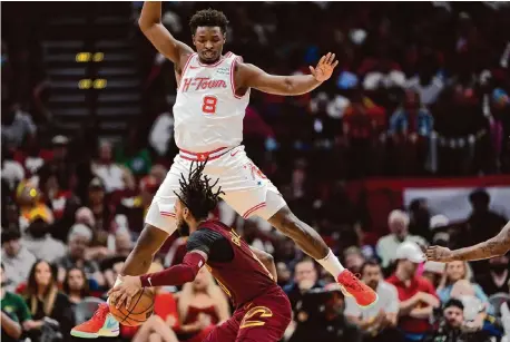  ?? David J. Phillip/Associated Press ?? The Rockets’ Jae'Sean Tate takes his defense against the Cavaliers’ Darius Garland to new heights Saturday.