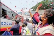 ??  ?? COVID-19 frontline workers shower flower petals on stranded migrants travelling to their native places, during the ongoing COVID-19 nationwide lockdown, in Bengaluru, on Thursday
