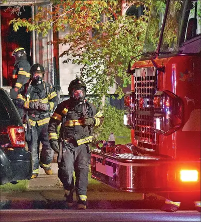  ?? Photos by Matthew Liebenberg ?? Left and bottom right: Swift Current firefighte­rs in full gear with breathing apparatus leave the home after the fire has been contained. Top right: Fire trucks on the scene after the house fire has been controlled, May 24. The home is lit up with a powerful floodlight mounted on the top of the front fire truck.