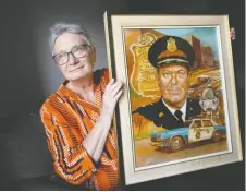  ?? DAX MELMER ?? Shirley Ann Shuttlewor­th holds a portrait of her father, John Shuttlewor­th, given to him when he retired from the Windsor police force.