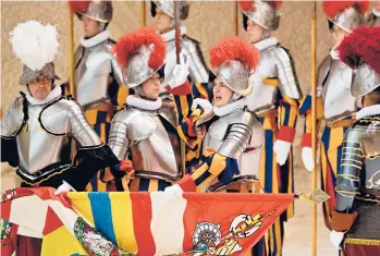  ?? ANDREAS SOLARO/GETTY-AFP ?? A Swiss Guard recruit, second from right, holds the Swiss Guard flag during a swearing-in ceremony Friday at the Vatican. This year, 36 recruits were added to the world’s oldest military unit. The ceremony is held annually on May 6 to commemorat­e the deaths of 147 comrades as they protected Pope Clement VII in 1527.