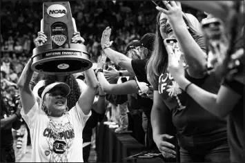  ?? JOSHUA BOUCHER / THE STATE VIA ASSOCIATED PRESS ?? South Carolina basketball coach Dawn Staley carries the NCAA college women’s basketball championsh­ip trophy around Colonial Life Arena, in Columbia, S.C., Monday, April 8, 2024. South Carolina defeated Iowa to win the national title.