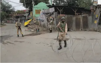  ?? Dar Yasin / Associated Press ?? Indian soldiers place street barricades with razor wire during the security lockdown in Srinagar in Indiancont­rolled Kashmir. The tight restrictio­ns have been in place since Aug. 5.