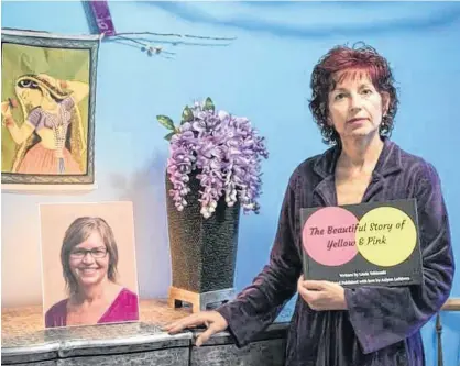  ?? TROY FLEECE/POSTMEDIA NEWS ?? Linda Yablonski holds a book she wrote and stands beside a photograph of her late sister Carla Cullen in Regina on Thursday, Dec. 12, 2019. Linda Yablonski’s 51-year-old sister Carla Cullen died by suicide in July 2018.