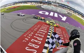  ?? (Logan Riely/Getty Images) ?? Ryan Blaney, driver of the #12 Menards/Cardell Cabinetry Ford, takes the checkered flag to win the Cup Series FireKeeper­s Casino 400 at Michigan Internatio­nal Speedway Sunday.