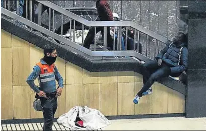  ?? XAVIER GÓMEZ ?? Un vigilante de seguridad y un vendedor ambulante ayer por la tarde en la estación de Catalunya