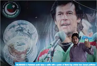  ??  ?? ISLAMABAD: A Pakistani youth takes a selfie with a poster of World Cup cricket hero turned politician and head of the Pakistan Tehreek-e-Insaf (Movement for Justice) party Imran Khan in Islamabad. —AFP