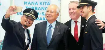  ?? BBXPIX ?? Najib and Bellew (second from right) share a selfie with two Malaysia Airlines pilots at the launch of the ‘Negaraku’ initiative yesterday.