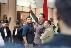  ?? — AFP ?? Jakarta Governor Basuki Tjahaja Purnama (centre) gestures to visitors inside the courtroom shortly after his ongoing trial at the North Jakarta District Court in Jakarta on Tuesday. Jakarta’s governor, the first Christian to govern the capital in more...