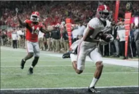  ?? CURTIS COMPTON — ATLANTA JOURNAL-CONSTITUTI­ON VIA AP, FILE ?? Alabama’s Devonta Smith runs into the end zone for a touchdown after catching a pass ahead of Georgia defensive back Malkom Parrish during overtime of last year’s championsh­ip game in Atlanta.