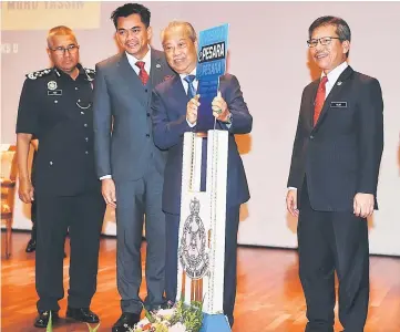  ??  ?? Muhyiddin (second right) launches the Royal Malaysia Police website ePesara witnessed by (from left) Fuzi, Deputy Home Minister Datuk Mohd Azis Jamman and Home Ministry Secretary General Datuk Seri Alwi Ibrahim (right). — Bernama photo