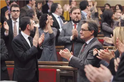  ??  ?? Aplausos. El presidente catalán, Artur Mas (de anteojos) celebra, ayer, junto a los diputados, en el Parlamento.