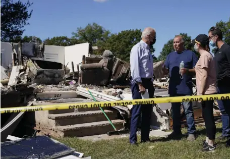  ?? Ap pHOtOs ?? ‘CODE RED’: President Biden talks to people Tuesday while touring a neighborho­od in Manville, N.J., heavily damaged by Hurricane Ida. XXX, Biden speaks about climate change.