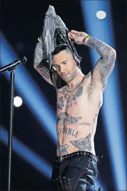  ?? [MARK HUMPHREY/THE ASSOCIATED PRESS] ?? Adam Levine of Maroon 5 rips off his tank top during the halftime show of the Super Bowl on Sunday in Atlanta.
