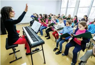  ??  ?? Anne-Marie Saint-Jacques leads the children through their song repertoire in rehearsal.