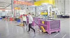  ??  ?? A worker pulls a trolley containing car interior pieces for a major European car maker in the American Industrial Park in Shenyang. While foreign firms complain about being locked out of large swathes of China’s vast market, the door has cracked open a...