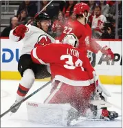  ?? DUANE BURLESON — THE ASSOCIATED PRESS ?? New Jersey Devils’ Jesper Bratt, left, collides with Detroit Red Wings center Michael Rasmussen, top, and goaltender Alex Lyon during Detroit’s 4-0home victory Wednesday.