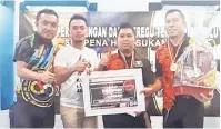  ??  ?? JUARA: Kigen (dua kiri) menyampaik­an hadiah kepada pasukan Black Monkey di Bintulu, kelmarin.