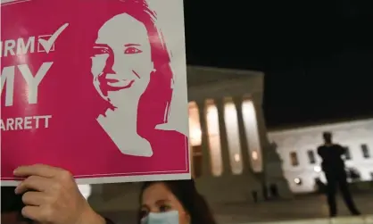  ??  ?? An Amy Coney Barrett supporter holds aloft a poster outside the supreme court in October. The Christian right could be further emboldened after her controvers­ial appointmen­t. Photograph: Roberto Schmidt/AFP/Getty Images