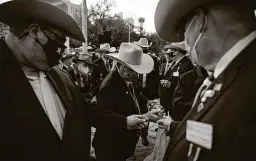  ??  ?? Steve Manis pours Texas whiskey for fellow members of the Sons of the Republic of Texas for their traditiona­l toast during the “Dawn at the Alamo” ceremony.