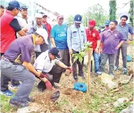  ??  ?? EWON (duduk, dua kiri) ketika menanam pokok hiasan sempena gotong royong itu.