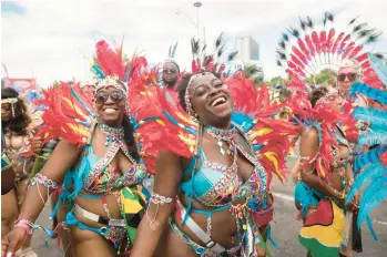  ?? TIJANA MARTIN/THE CANADIAN PRESS ?? Feathered and beaded participan­ts perform Saturday during the Grand Parade at the Caribbean Carnival in Toronto. The annual event resumed in the city after a two-year hiatus due to the COVID-19 pandemic.