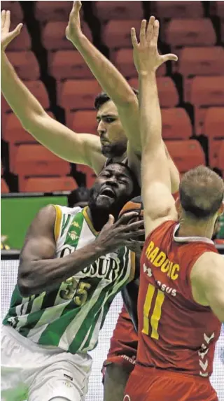  ?? JUAN FLORES ?? Youssou Ndoye intenta penetrar a canasta ante dos rivales