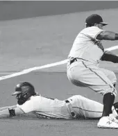  ?? MARTA LAVANDIER/AP ?? Marlins’ Miguel Rojas (19) slides into third base as Baltimore Orioles third baseman Maikel Franco (3) is late with the tag during Tuesday’s game.