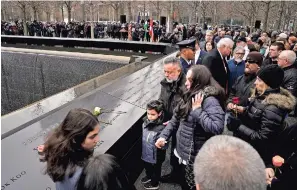  ?? ?? Los dolientes colocan flores sobre los nombres de las víctimas