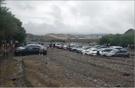  ?? PHOTOS BY NATIONAL PARK SERVICE VIA AP ?? Cars are stuck in mud and debris from flash flooding at The Inn at Death Valley in Death Valley National Park on Friday.