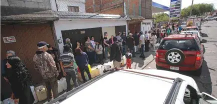  ??  ?? ESPERA. Cientos de personas y vehículos esperan ser atendidos en una estación de Mihcoacán. (EFE)