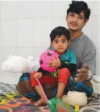  ??  ?? (Left) This file photograph taken on Jan 31, 2016 shows Bangladesh­i man Abul Bajandar dubbed the ‘Tree Man’ as he sits at the Dhaka Medical College Hospital. (Right) In this photograph taken on Jan 4, 2017, Bajandar relaxes with his daughter in a ward...