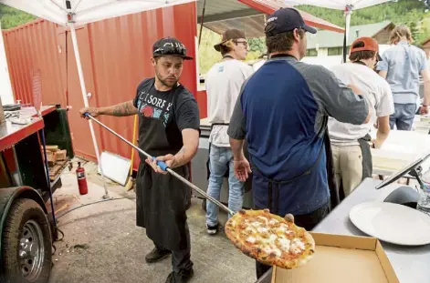  ??  ?? Gage Groves of Longmont slings a pizza from the wood-fired oven at Campfire in Evergreen. Andy Colwell, Special to The Denver Post