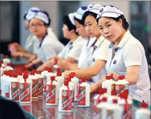  ?? JIANG DONG / CHINA DAILY ?? Workers pack bottles of liquor at the Kweichow Moutai Co Ltd plant in Maotai, a town in southweste­rn China’s Guizhou province.