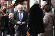  ?? (AP/Henry Nicholls) ?? British Prime Minister Boris Johnson visits a covid-19 vaccinatio­n center Friday at a pharmacy in Sidcup in southeast England. In a broadcast, Johnson urged people to get booster shots. “I’m seeing the storm clouds gathering over parts of the European continent,” he warned.