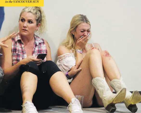  ?? AL POWERS / INVSION / THE ASSOCIATED PRESS ?? Women take refuge inside the Sands Corporatio­n plane hangar after a man broke his hotel room window and shot at crowds watching an outdoor concert in Las Vegas Sunday.