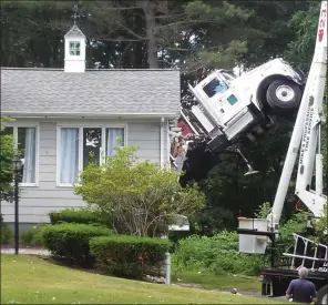  ?? Photo by Joseph Fitzgerald ?? No one was injured when this crane truck tipped over and smashed into a Pound Hill Road home on Monday afternoon.