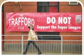  ?? Photos: AFP ?? Top: Supporters demonstrat­e against the proposed European Super League outside of Stamford Bridge stadium in London, England on Tuesday. Left: A banner against the proposed European Super League hangs from a pub close to Old Trafford stadium in Manchester, England on Wednesday.