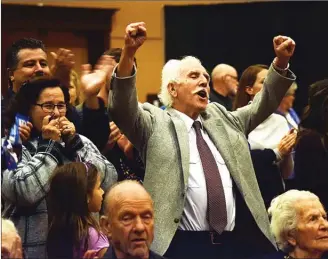  ?? JOE FRIES/Penticton Herald ?? John Vassilaki throws up his arms in celebratio­n after being announced as Penticton’s mayor-elect. Joining in the celebratio­n is his wife Barbara, left and other members of his family.