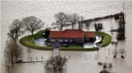  ?? FOTO HBVL ?? De familie liet een aarden wal rond de boerderij aanleggen om de hoeve te beschermen tegen Maasoverst­romingen, zoals hier in 2003.