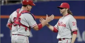  ?? JULIE JACOBSON — THE ASSOCIATED PRESS ?? Philadelph­ia Phillies catcher A.J. Ellis (34) congratula­tes relief pitcher Michael Mariot (31) after the Phillies defeated the New York Mets 10-8 Saturday in New York.