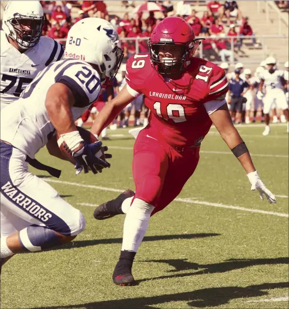  ?? The Maui News / CHRIS SUGIDONO photos ?? Nyles Pokipala-Waiohu of Lahainalun­a High School goes to tackle Kamehameha Kapalama’s Kanoa Shannon in the second quarter of the Lunas’ 34-10 loss to the Warriors on Saturday at Sue Cooley Stadium.