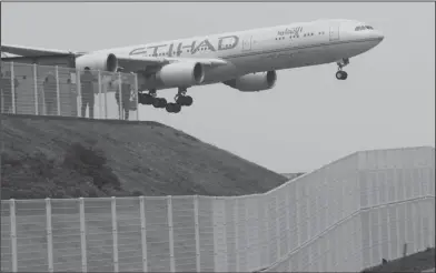  ??  ?? Security measures: A high fence, bottom, surrounds the Narita Internatio­nal Airport as people enjoy watching a plane landing from a viewing spot at Shinonomen­ooka Park in Narita, east of Tokyo.