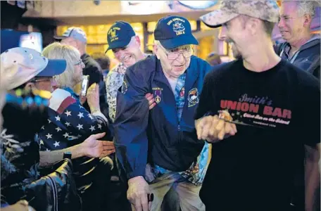  ?? Photograph­s by Kent Nishimura For The Times ?? WELL-WISHERS greet battleship Arizona survivor Lauren Bruner as he arrives at Smith’s Union Bar, which he used to visit while stationed at Pearl Harbor as a young man. Ed McGrath says the memories Bruner shared of the attack were even worse than he’d...