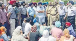  ?? SAMEER SEHGAL/HT ?? Khalsa College governing council chief Satyajit Majithia (second from right) talking to teachers, who are protesting the FIR against the principal and other officials, in Amritsar on Saturday.