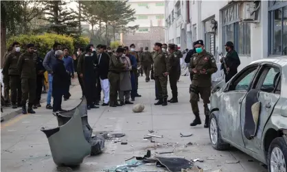  ?? Photograph: AFP/Getty Images ?? Security officials gather beside a damaged vehicle near the premises of a factory in Sialkot after police confirmed a Sri Lankan man was beaten to death.