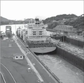  ?? STEVE MACNAULL, THE CANADIAN PRESS ?? The Danish cargo ship Olivia Maersk squeezes through the final lock of the Panama Canal, which is identified as one of dozens of transporta­tion choke points around the world.