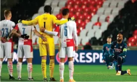  ??  ?? The Arsenal captain Alexandre Lacazette takes a knee in front of the Slavia players. Photograph: Martin Divíšek/EPA