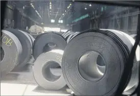  ?? Jeff Roberson / Associated Press ?? Rolls of finished steel sit at a facility in Granite City, Ill. Tariffs have swelled the cost of materials needed by U.S. companies, leaving them at a competitiv­e disadvanta­ge against foreign rivals unburdened by import taxes.