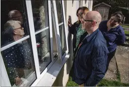  ?? JACOB KING — PA VIA AP ?? Olive Trotman, 76, left, is visited on Mother’s Day by her son, Mark, his wife, Denise, and his sister, Kelly, in Napton, England, on Sunday. Trotman suffers from a pulmonary disease and is taking the COVID-19self-isolation precaution seriously.